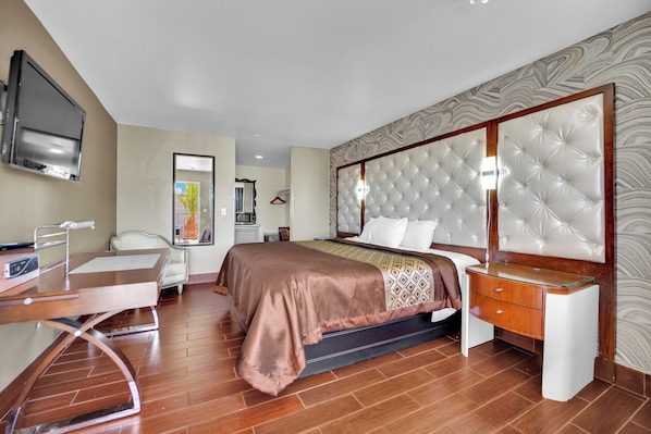 Une chambre d’hôtel moderne équipée d’un lit, d’une table de chevet, d’une télévision et d’un bureau avec une chaise.