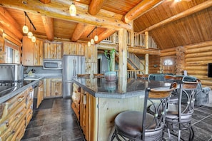 Ein Blockhaus-Interieur mit Küche, Essbereich und einer Treppe.