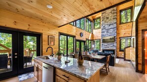 Eine moderne Küche mit Granit Arbeitsplatte, Holzschränken und einem Kamin aus Stein.