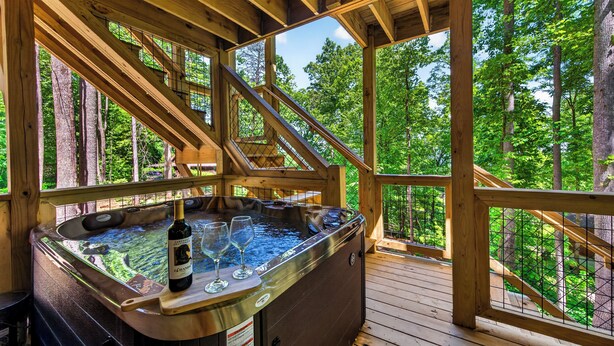 Ein Whirlpool mit Holzterrasse und Blick auf einen Wald.
