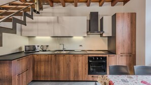 Une cuisine moderne avec des meubles en bois, un four encastré et un four à micro-ondes.