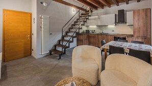 Une cuisine moderne avec des meubles en bois, un four à micro-ondes encastré et un coin repas comprenant une table et des chaises.