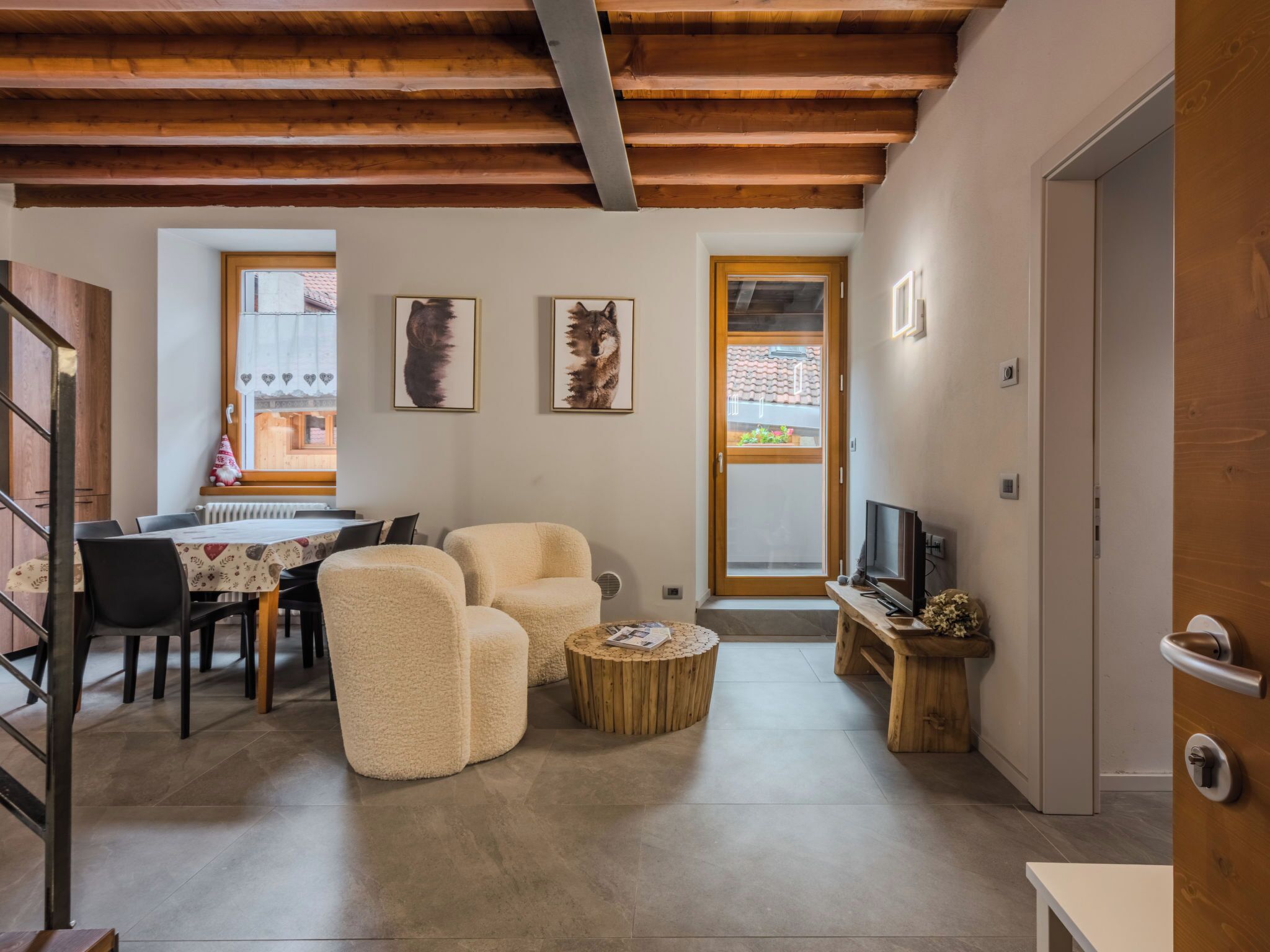 Un salon confortable avec un coin repas, un téléviseur et un escalier.