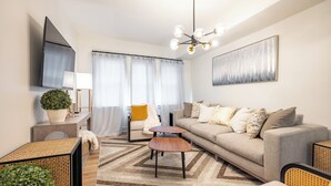 A modern living room with a sofa, coffee table, and a TV mounted on the wall. - 2-bedroom apartment in wonderful Indianapolis near State Fairgrounds (Indianapolis)