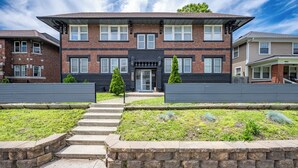 A two-story brick building with a flat roof, a central entrance with a door, and a small front garden with steps leading to the entrance. - 2-bedroom apartment in wonderful Indianapolis near State Fairgrounds (Indianapolis)