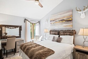 A bedroom with a large bed, a desk, a chair, a ceiling fan, and a wall-mounted deer head decoration. - Summit View Ski and Golf Retreat w/hot tub & Sauna (Winhall)