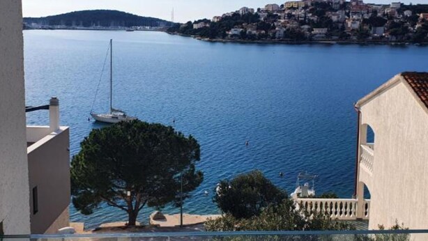 A coastal view with a building, a tree, and a body of water. - Villa Seka (Rogoznica)