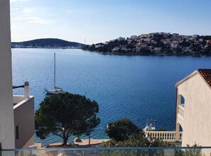 A coastal view with a building, a tree, and a body of water. - Villa Seka (Rogoznica)