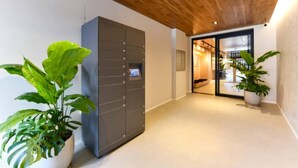 Un corridoio con un armadietto moderno, piante in vaso e un soffitto in legno.