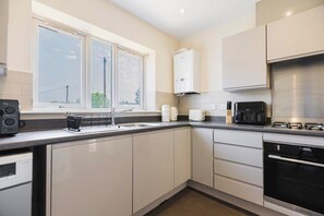 Una cucina moderna con forno a incasso, macchina da caffè e una finestra vista esterna.