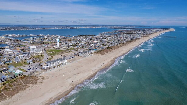 An aerial view of a coastal town with a beach, buildings, and a lighthouse. - Walk to Downtown Beaufort | 4BR Coastal Cottage (Beaufort)