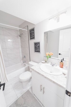 Ein modernes Badezimmer mit Badewanne, Toilette und Waschbecken.