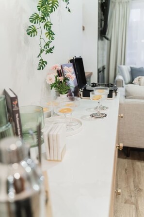 A dining table with glassware, books, and a potted plant. - Chic Central 3BR: Martini Bar & Patio. Near DT/WEM (Edmonton)