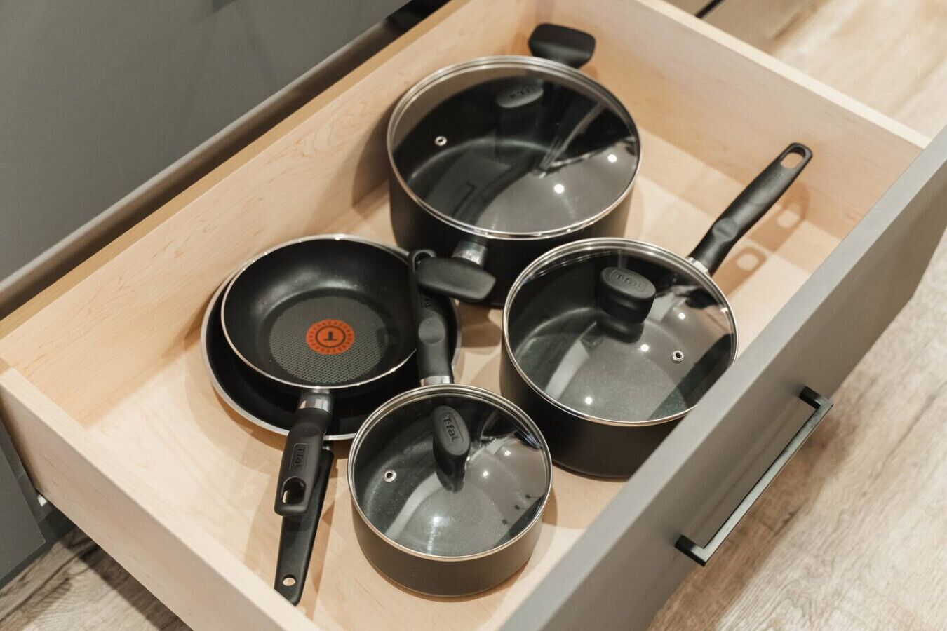 Un tiroir contenant quatre casseroles et poêles.