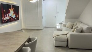 Een moderne leefruimte met een eethoek, een zithoek en een open haard.
