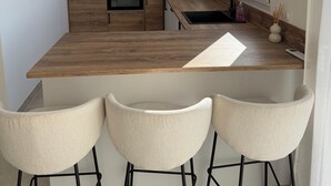 Een moderne keuken met houten kasten, een centraal eiland en een raam.