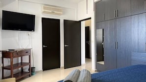 Ein Hotelzimmer mit Bett, Schreibtisch, Fernseher und Kleiderschrank.