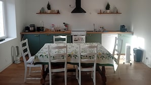 Una cucina con tavolo e sedie, un fornello e un lavello.