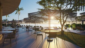 An outdoor dining area with tables and chairs, palm trees, and a view of the water. - Pipa Island Resort - GAV Resorts (Tibau do Sul)