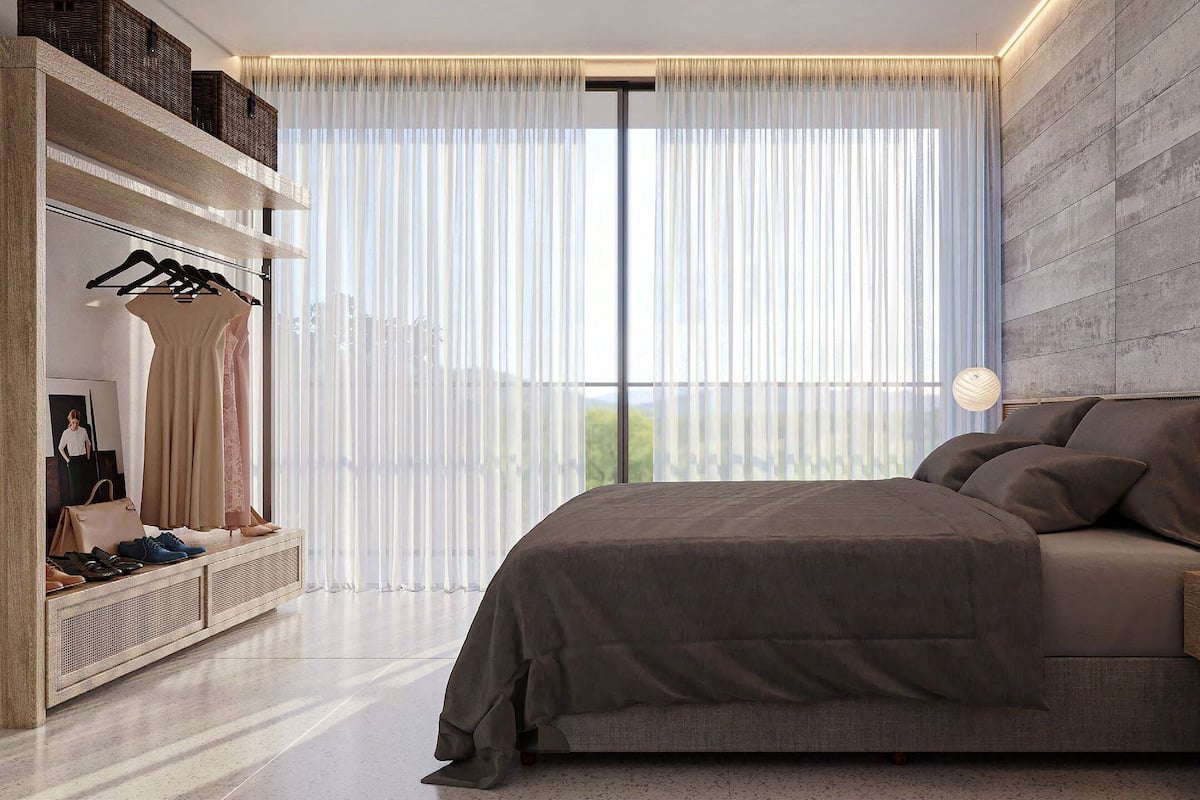A modern bedroom with a large bed, a wardrobe, and a window with sheer curtains.