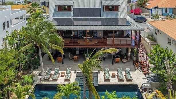 A two-story building with a rooftop terrace, a swimming pool, and outdoor seating areas. - Bali Suites | The Villa a Private Paradise (Willemstad)