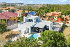 Ein modernes Haus mit Swimmingpool, mehreren Zimmern und Blick auf die Umgebung.