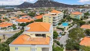 A residential area with multi-story buildings, a swimming pool, and a mountain in the background.