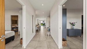 Ein modernes Interieur mit einem Flur, der zu einer Essecke, einem Schlafzimmer und einem Wohnbereich führt.