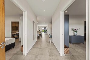 Ein modernes Interieur mit einem Flur, der zu einer Essecke, einem Schlafzimmer und einem Wohnbereich führt.