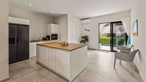 Eine moderne Küche mit einer zentralen Kochinsel, integrierten Geräten und einer Glastür zum Patio.
