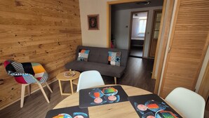 Un comedor con una mesa redonda, sillas y un sofá.
