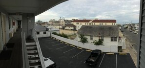 Um estacionamento com um edifício ao fundo, uma escadaria e vista da área circundante.