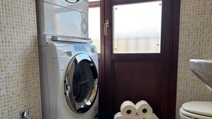 A bathroom with a washing machine, bidet, toilet, and a tiled floor. - Calixa - Sheaves - Comfortable apartment for two people, private parking. (Cagliari)