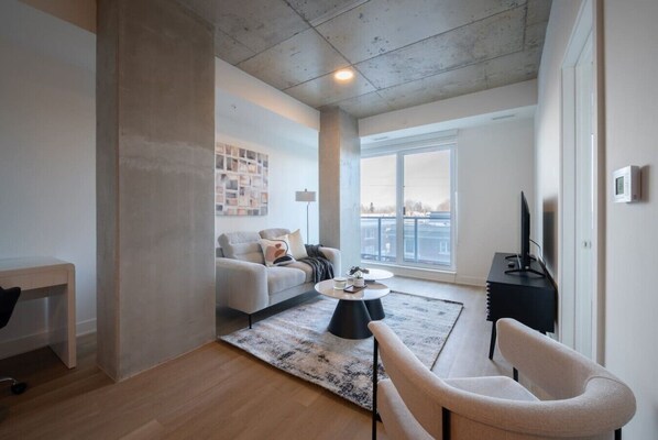 A modern living room with a sofa, coffee table, and TV stand.