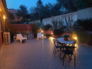 An outdoor patio with chairs and a table, surrounded by plants and a wall with a mural. - Here everyone is who they want to be. Welcome to a unique and superbly maintained room. (Marche)
