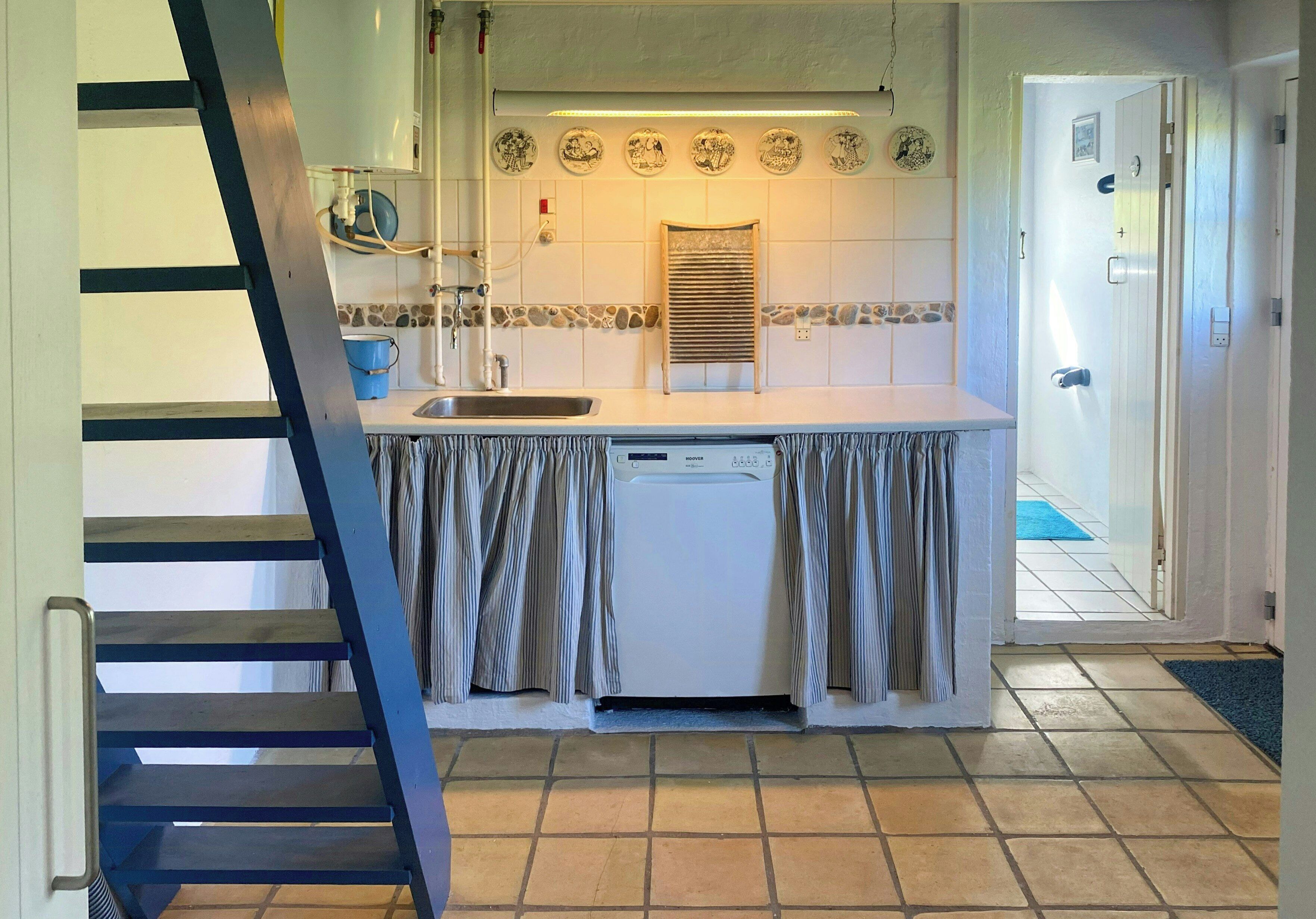 A kitchen with a built-in dishwasher, a sink, and a tiled backsplash.