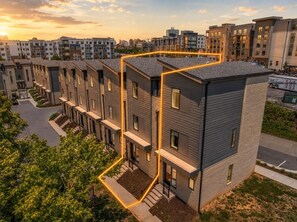 Un immeuble d’appartements moderne doté d’une cour intérieure, de nombreux balcons et offrant une vue sur le paysage urbain environnant.