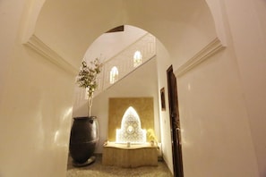 A hallway with an arched ceiling, a decorative fountain, and a potted plant. - Riad Étoile du Sud (Sidi Abdallah Ghiat)