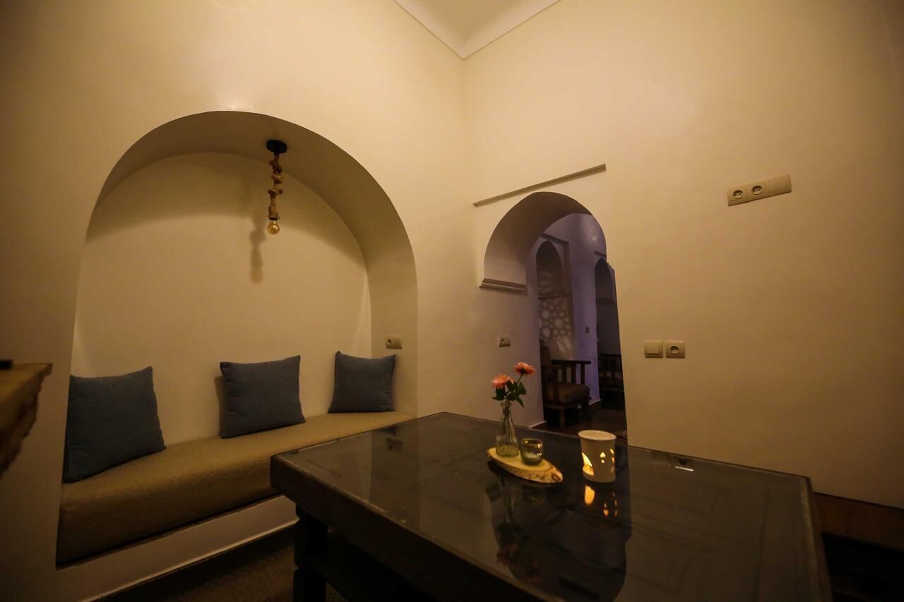 Una stanza con un divano, un tavolino in vetro e un arco.