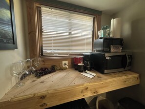 Un piano di lavoro in cucina con un tostapane, una macchina per il caffè e una confezione di snack.