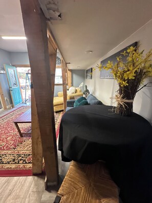 Una stanza con un letto, un divano, un tavolino e un vaso decorativo con fiori.