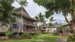 Een resort met meerlaags gebouwen, balkons en weelderige begroeiing.