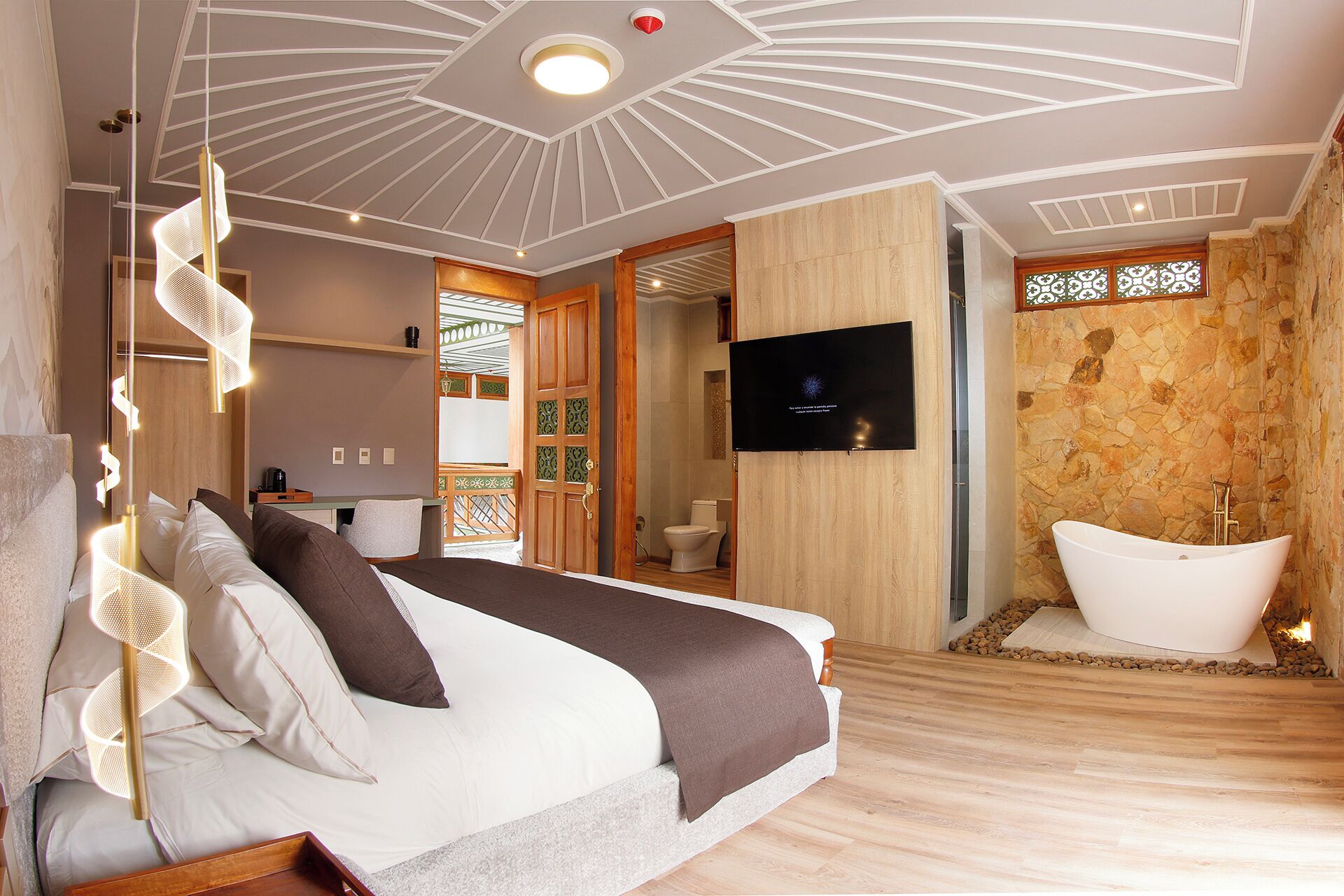 Une chambre à coucher moderne, équipée d’un lit, d’une télévision et d’une salle de bain avec baignoire.