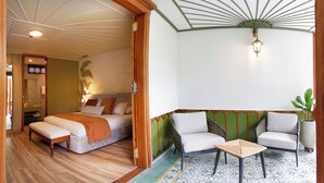 A room with a bed, two chairs, a small table, and a decorative ceiling fan. - El Molino Ecohotel (Salento)