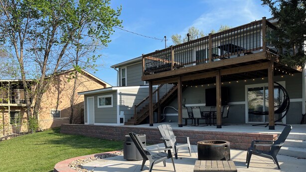 A patio with outdoor furniture, a fire pit, and a deck with a railing. - 4 bedrooms plus an outdoor entertainment area. World Cup ready! (Shawnee)