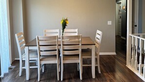 A dining area with a table and chairs, a ceiling fan, and a hallway. - 4 bedrooms plus an outdoor entertainment area. World Cup ready! (Shawnee)