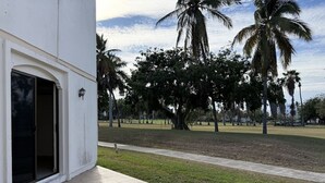 Un edifici amb un pati enrajolat, una porta i un fanal.