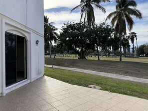 Ein Gebäude mit einer gefliesten Terrasse, einer Tür und einer Laterne.