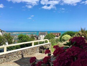 Küstensicht mit Steinbauten, Meer und blauem Himmel.