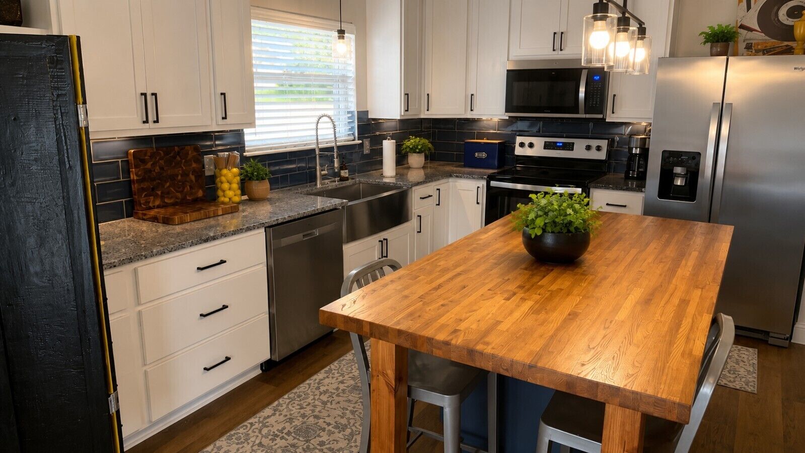 A modern kitchen with white cabinets, stainless steel appliances, and a wooden island with bar stools.